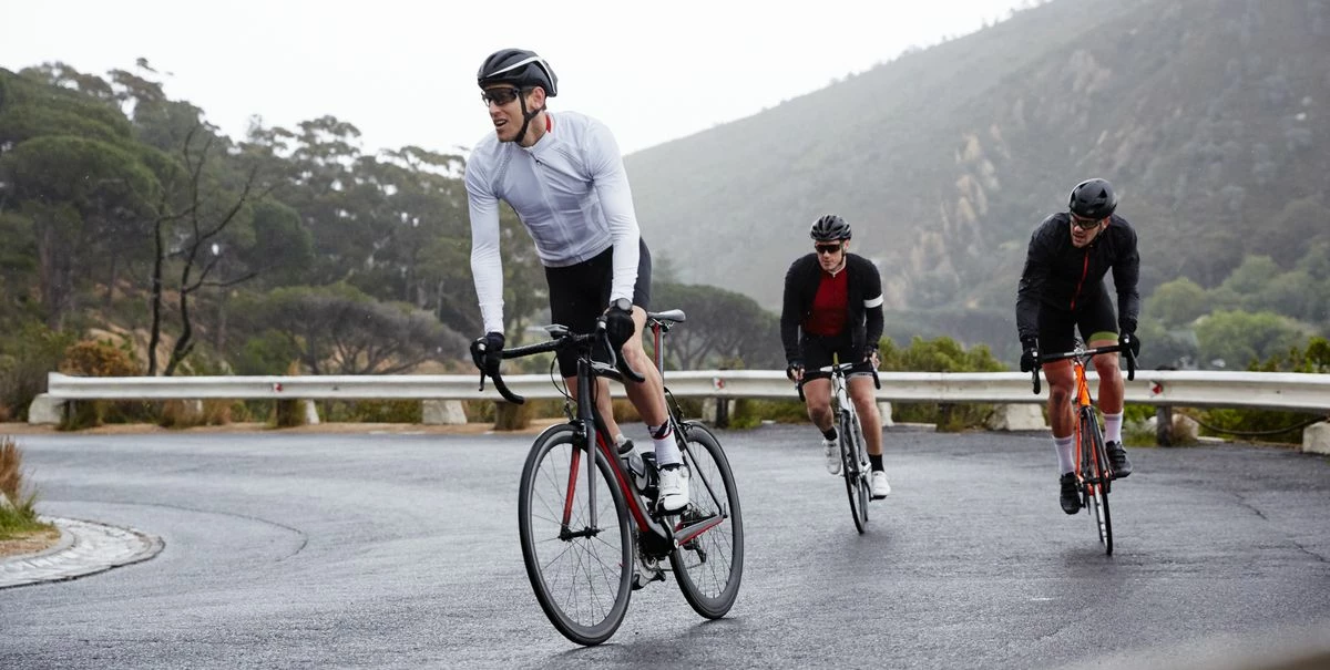 Forside 2 Forside -Trollkids Salg male cyclists cycling uphill on wet road royalty free image 970437296 1553284308